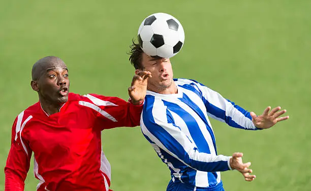 Soccer players contesting a header