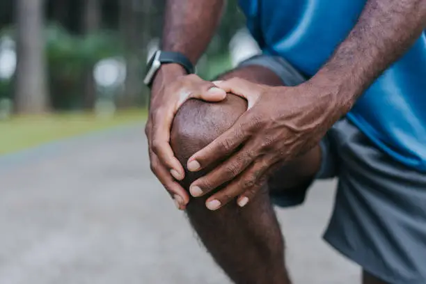 Individual holding a painful knee
